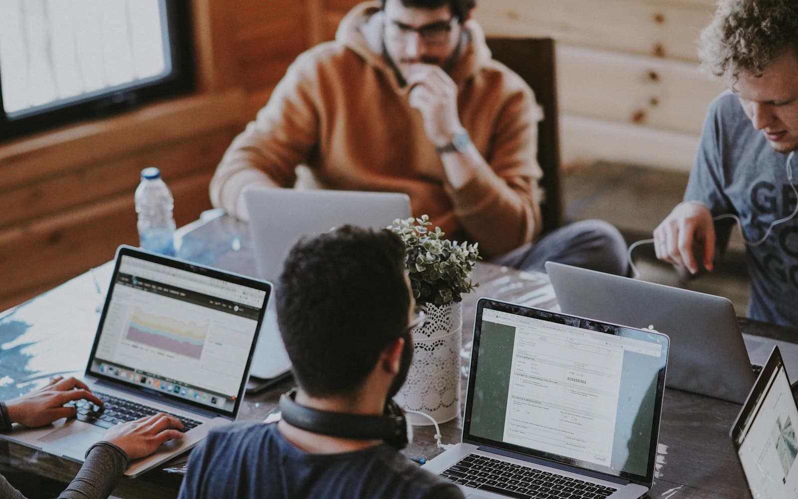 Team arbeitet gemeinsam mit Laptops an einem Tisch